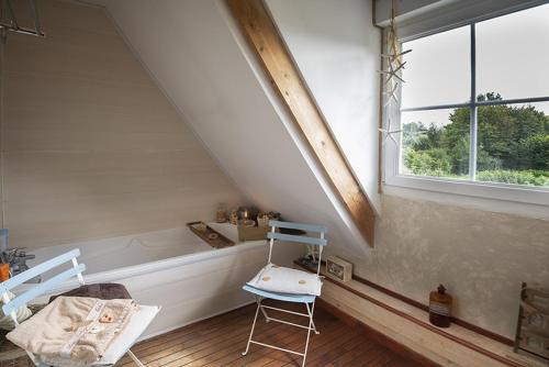 Zimmer im Dachgeschoss mit Badewanne und Stuhl in der Unterkunft La longère en Baie - au calme sur Saint Valery pour 4 in Saint-Valery-sur-Somme