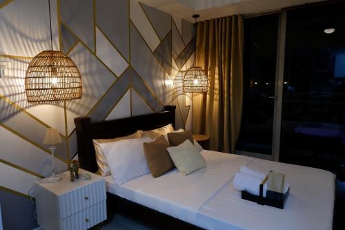 a bedroom with a large white bed with two lamps at Azure Urban Beach Resort by Melrose Avenue in Manila