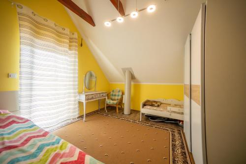 a bedroom with yellow walls and a bed and a window at Nebesa so tudi na zemlji in Tomaž pri Ormožu