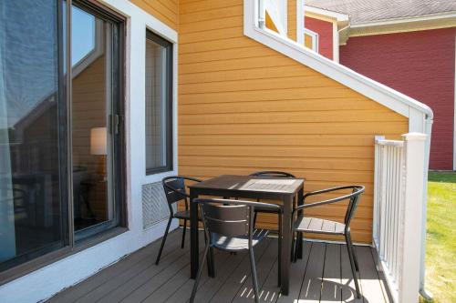a table and chairs on a porch with a house at Estrimont in Magog-Orford