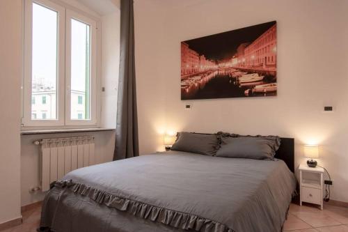 a bedroom with a bed and a painting on the wall at [Burlo Garofalo] Modern Apartment *Wifi+Netflix* in Trieste