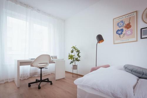 1 dormitorio con escritorio, 1 cama y 1 silla en Nový štýlový byt, blízko letiska, en Bratislava
