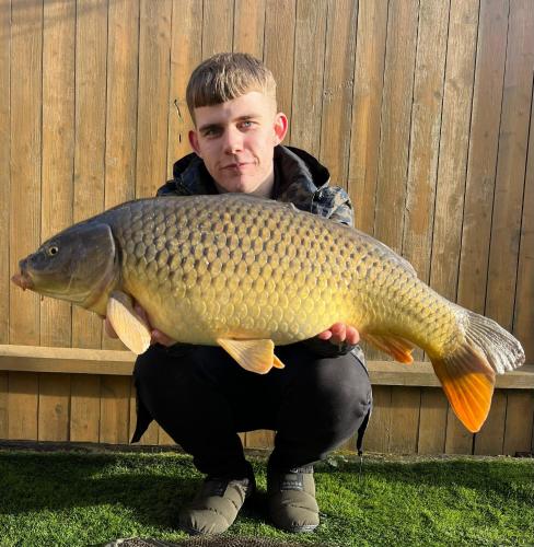 a man holding a large fish in his hands at The Windsor Lodge in Ellesmere