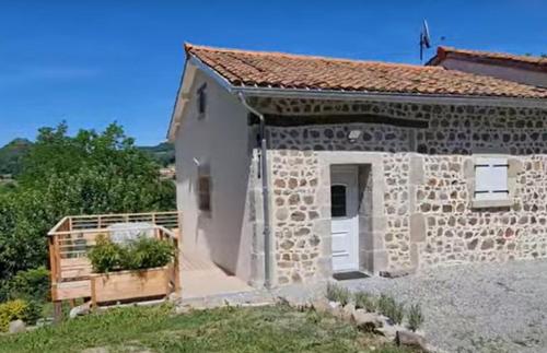 a stone building with a door and a fence at Gîte à la campagne in Manglieu