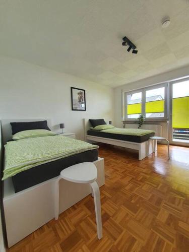 1 dormitorio con 2 camas y suelo de madera en Ferienwohnung Haunsheim, en Haunsheim