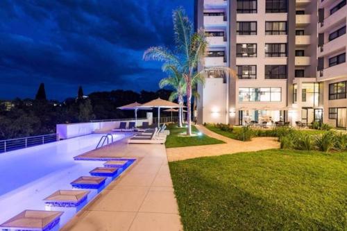 a building with a swimming pool at night at Luxury 1-bedroom Apartment With DSTV and Wi-Fi in Pretoria