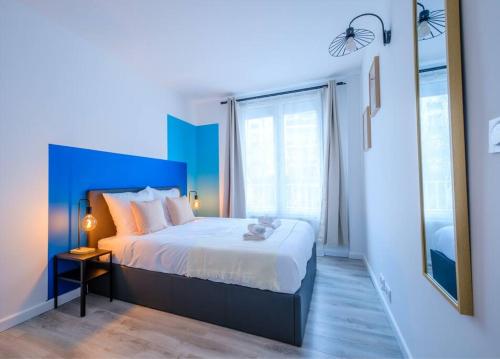 une chambre avec un grand lit avec une tête de lit bleue dans l'établissement Blue Paradise, à Reims