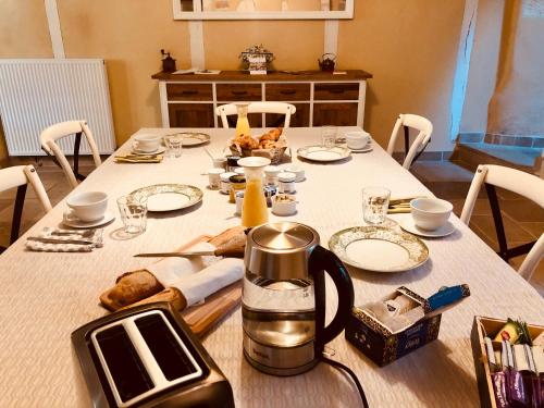 una mesa con mantel blanco y tetera en L’AMANTINE Chambres d’hôtes et gîte, en Bourges