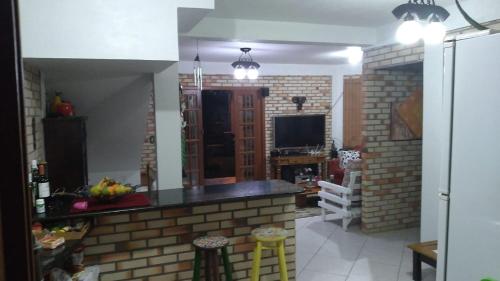 a room with a kitchen with a brick wall at Casa da Barra da Ibiraquera in Imbituba