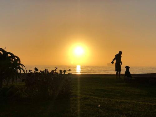 a woman standing on the beach watching the sunset at Namibia Coastal Retreat in Walvis Bay
