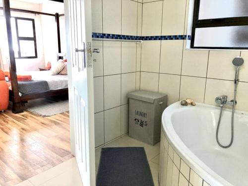 ein Bad mit einer Badewanne und ein Schlafzimmer in der Unterkunft Namibia Coastal Retreat in Walvis Bay