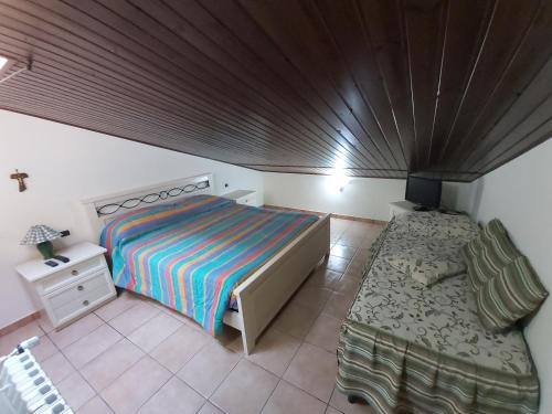 een kleine slaapkamer met een bed en een stoel bij Snowflake Apartment in Campo di Giove