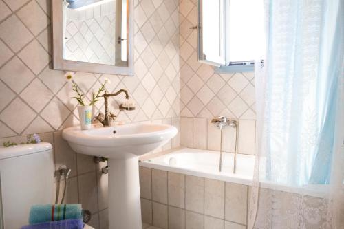 a bathroom with a sink and a tub and a toilet at Villa Simeoni in Lefkada
