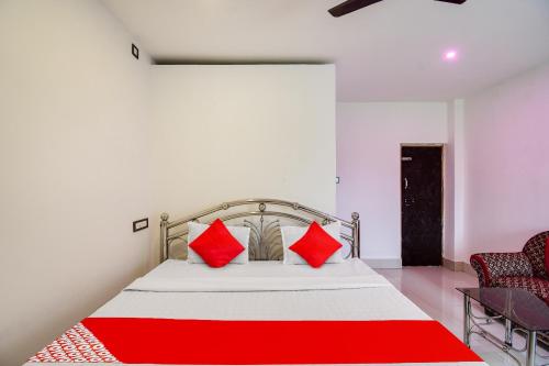 a bedroom with a bed with red pillows on it at Hotel O Mango Leaf Hotel & Restaurant in Baharampur