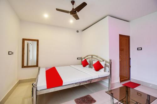 a bedroom with a bed and a ceiling fan at Hotel O Mango Leaf Hotel & Restaurant in Baharampur