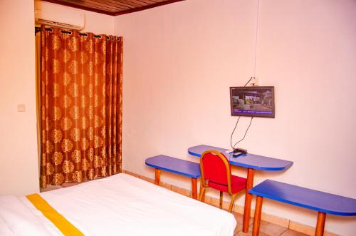 a room with a table and two chairs and a tv at SUP HOTEL in Douala