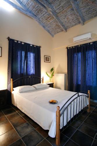 a bedroom with a large bed with blue curtains at Villa Simeoni in Lefkada