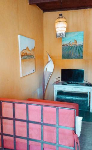 a living room with a red couch and a desk at Vila Santa Rosa Guest House in Ilhabela