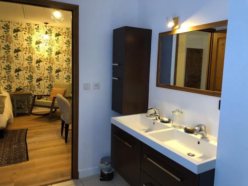 y baño con lavabo y espejo. en L’AMANTINE Chambres d’hôtes et gîte, en Bourges
