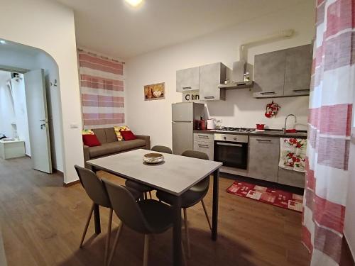 een keuken en een woonkamer met een tafel en stoelen bij SAN PAOLO ROMA HOLIDAY HOME in Rome