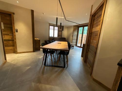 a dining room with a wooden table and chairs at Gite Roche Des Ducs avec Piscine toute l'année, Spa, Sauna, Hammam in Rochesson