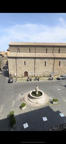 a building with a fountain in the middle of a parking lot at Il Viterbino Struttura convenzionata con impianti termali in Viterbo