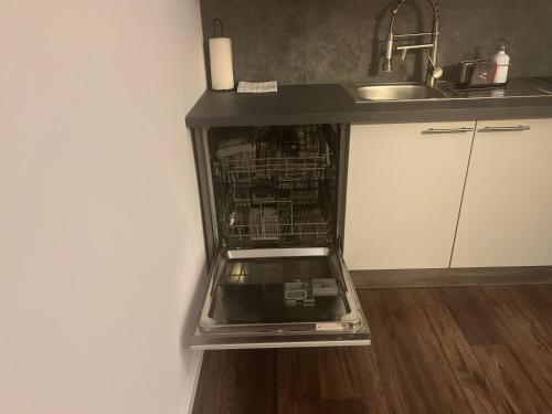 a dishwasher with its door open in a kitchen at Golden Gate Orth an der Donau in Orth an der Donau