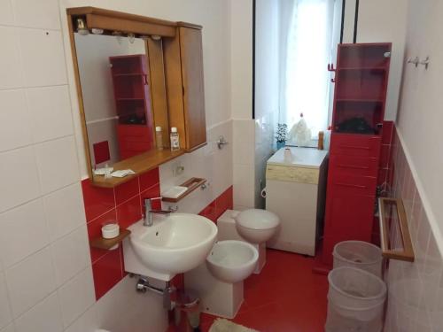 a bathroom with a sink and a toilet and a mirror at La casa di Anna in Collegno