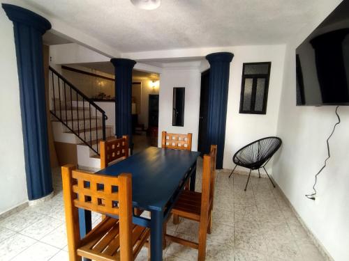 a dining room with a blue table and chairs at Hotel & Hostal Santuario in San Miguel de Allende