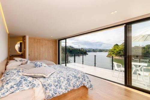 um quarto com uma cama e vista para a água em Espectacular Villa en Guatapé con jacuzzi en frente de la represa em El Peñol