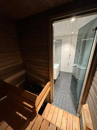 a sauna with a shower and a tub at Apartment Ahkiomaantie in Rovaniemi