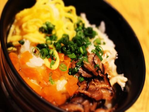 a black bowl of food with meat and vegetables at Hotel Lexton Kagoshima in Kagoshima