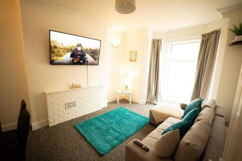a living room with a couch and a tv on the wall at Spacious Sea-View Flat w SmartTV in Lowestoft