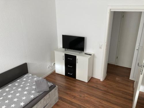 uma sala de estar com uma televisão num armário branco em Ferienwohnungen Funke für Monteure in Apolda em Apolda