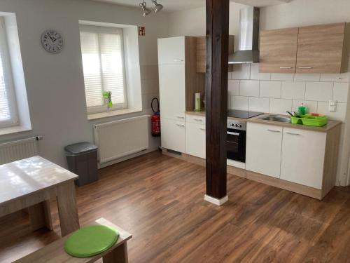 una cucina con armadietti bianchi e pavimenti in legno di Ferienwohnungen Funke für Monteure in Apolda a Apolda