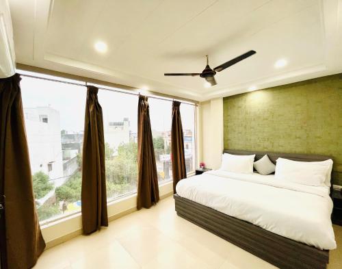 a bedroom with a bed and a large window at Heaven Hotel in Bareilly