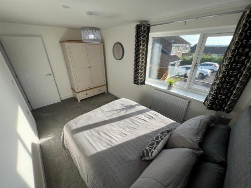 a bedroom with a bed and a large window at Modern, Two Double Bedroom House with Free Parking in Chepstow
