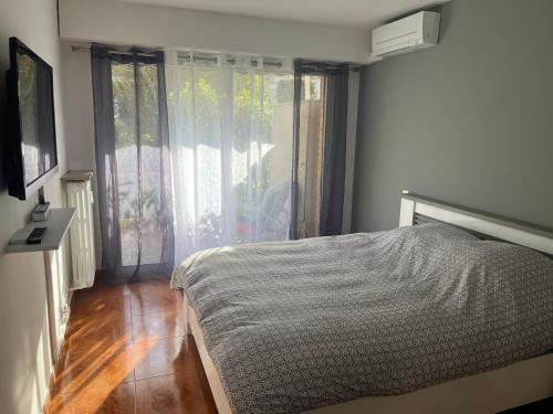 une chambre avec un lit et une grande fenêtre dans l'établissement 2 pièces, 4 couchages terrasse, garage, à Cannes