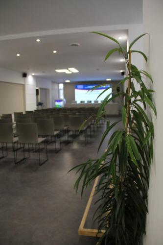 a potted plant in a waiting room with chairs at Hotel Tonnara Trabia in Trabia
