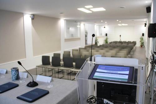 a conference room with a table with a screen and chairs at Hotel Tonnara Trabia in Trabia
