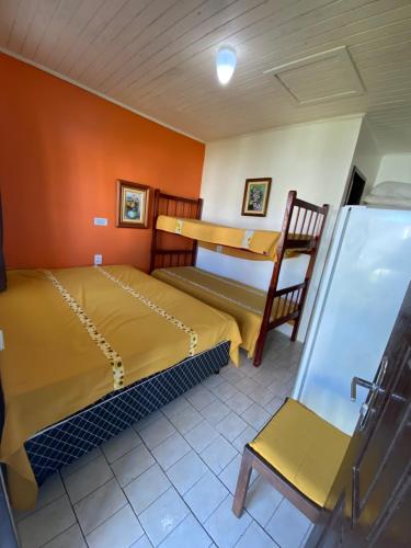 a room with two beds and a chair in it at Pousada Aventura in Passo de Torres