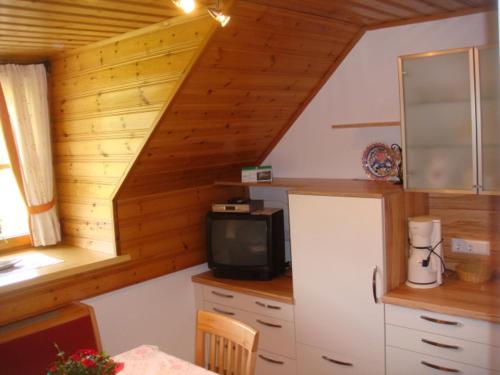 a kitchen with a refrigerator and a small tv at Ferienwohnung Boahof in Lessach