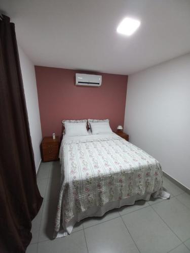 a bedroom with a large bed with a white comforter at Casa Climatizada com Piscina em Jacaraipe in Serra