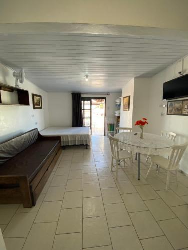 a room with a bed and a table and chairs at Pousada Aventura in Passo de Torres