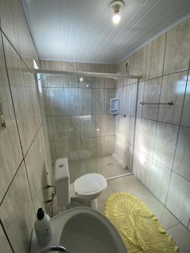 a bathroom with a shower and a toilet and a sink at Pousada Aventura in Passo de Torres