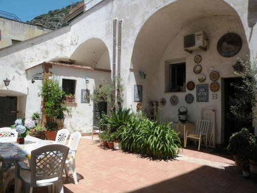 un patio con tavolo e sedie in un edificio di La Dolce Meta a Meta