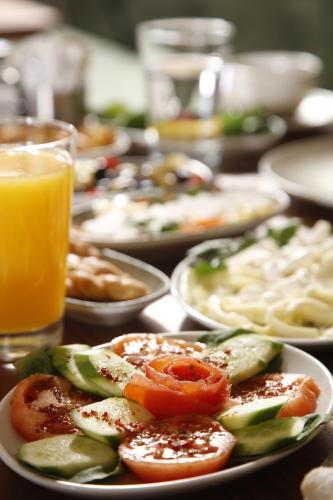 a table with plates of food and a glass of orange juice at Kate Hotel Special Class & SPA in Istanbul