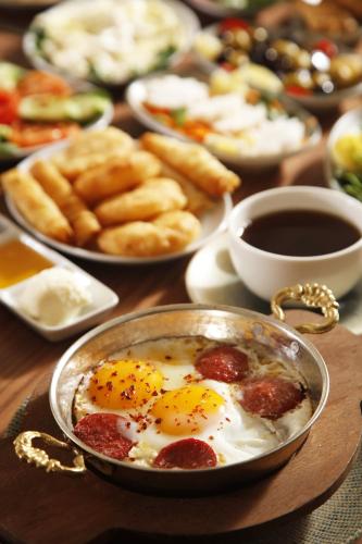 a table topped with plates of food with eggs and bread at Kate Hotel Special Class & SPA in Istanbul