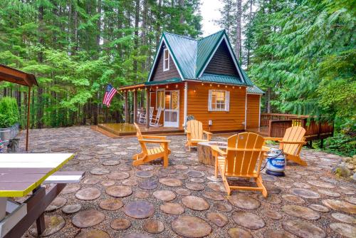a small cabin with rocking chairs and a patio at Adorable A-Frame Cabin, Steps to Lake Cushman! in Hoodsport
