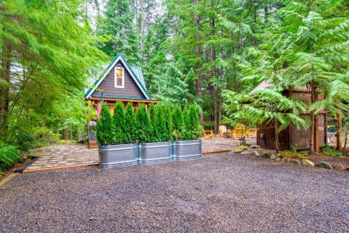 a home with a row of trees in front of a house at Adorable A-Frame Cabin, Steps to Lake Cushman! in Hoodsport